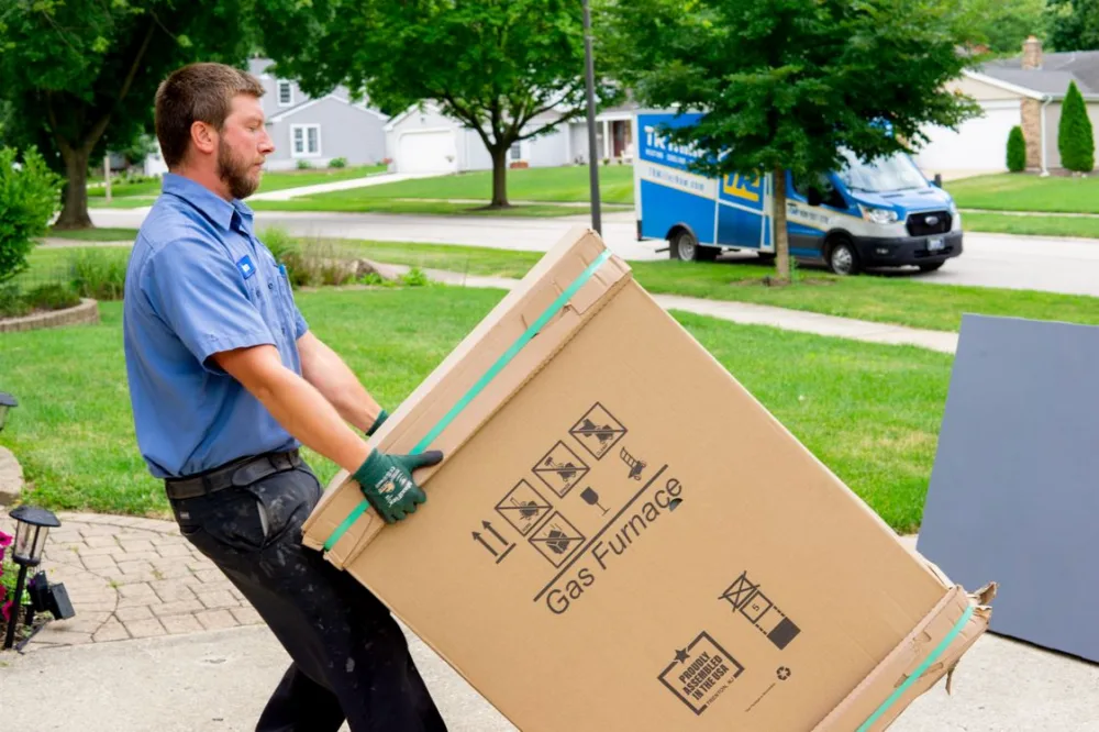 tr miller hvac technician moving a gas furnace in the chicago suburbs