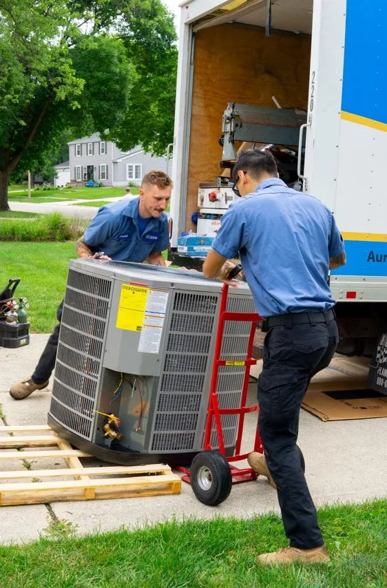 tr miller hvac technicians transporting an air conditioner in the western Chicago suburbs