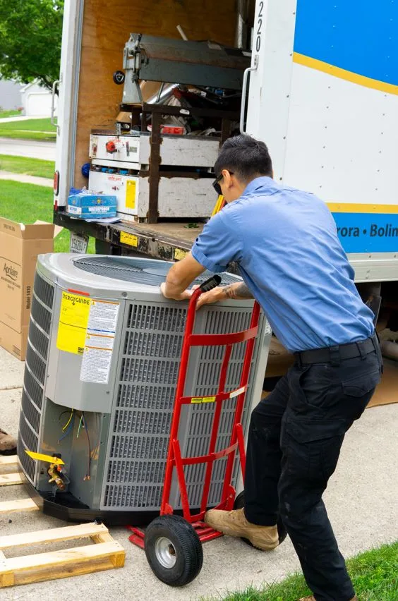 tr miller hvac technician loading an air conditioning unit in a chicagoland suburban home