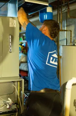 hvac technician working on a residential home heating system