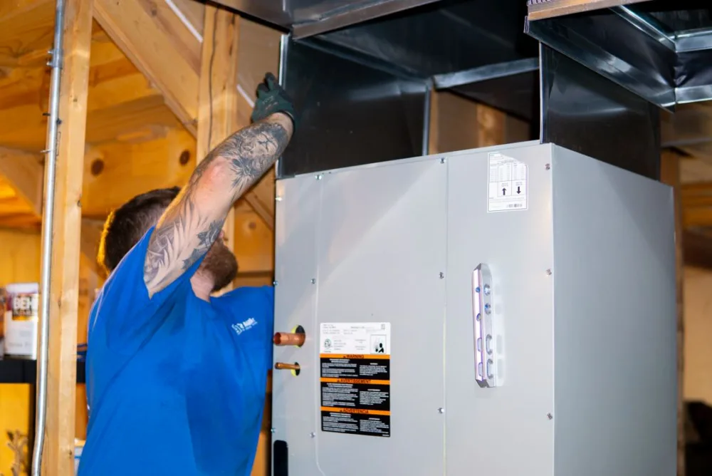 tr miller hvac technician installing a residential furnace at a chicago suburban home