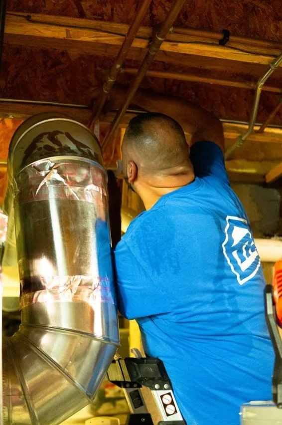 furnace repair technician working in a local home's basement