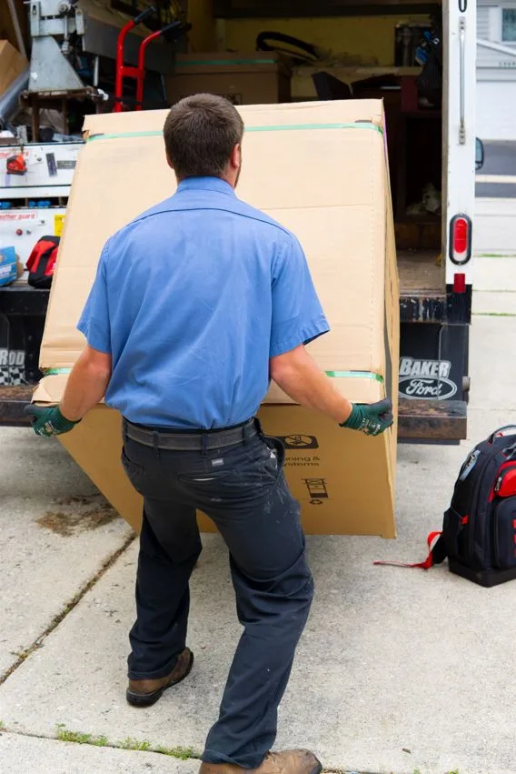 hvac technician unloading a furnace at a chicago suburban home