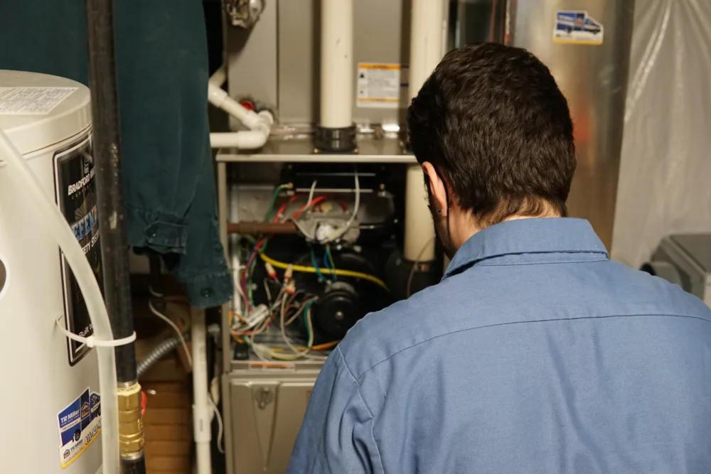 tr miller hvac technician performing a furnace inspection in the western chicago suburbs