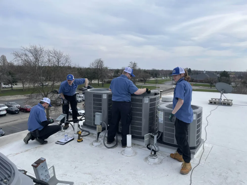hvac team repairing ac units on a residential apartment complex in the western chicago suburbs