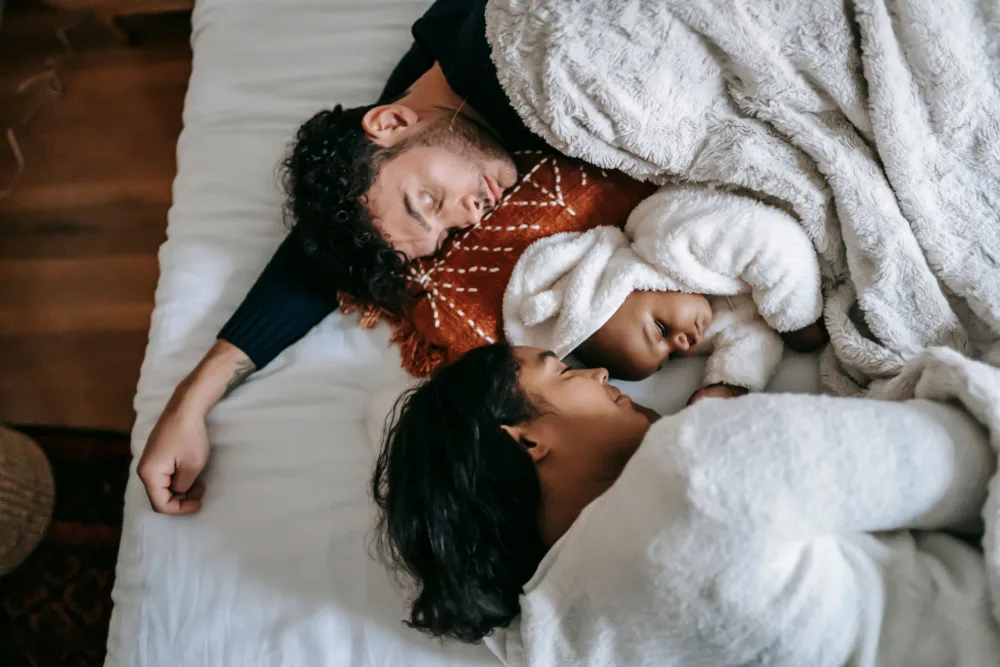 family resting comfortably in a bed