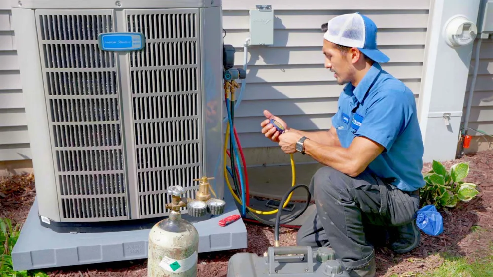 hvac technicial servicing a residential ac unit