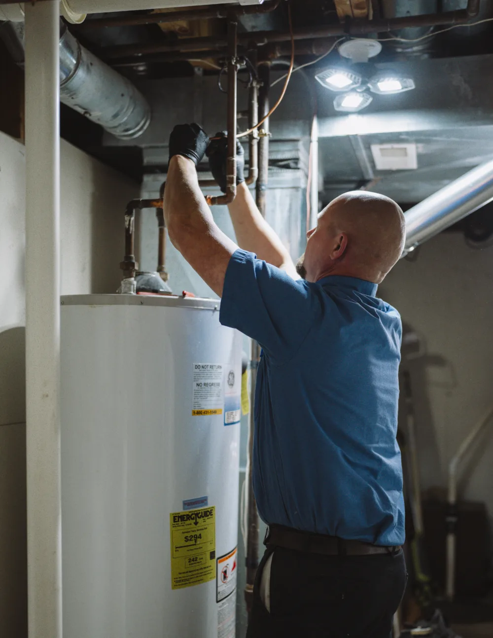 tr miller plumber repairing a tankless water heater in the Chicago suburbs